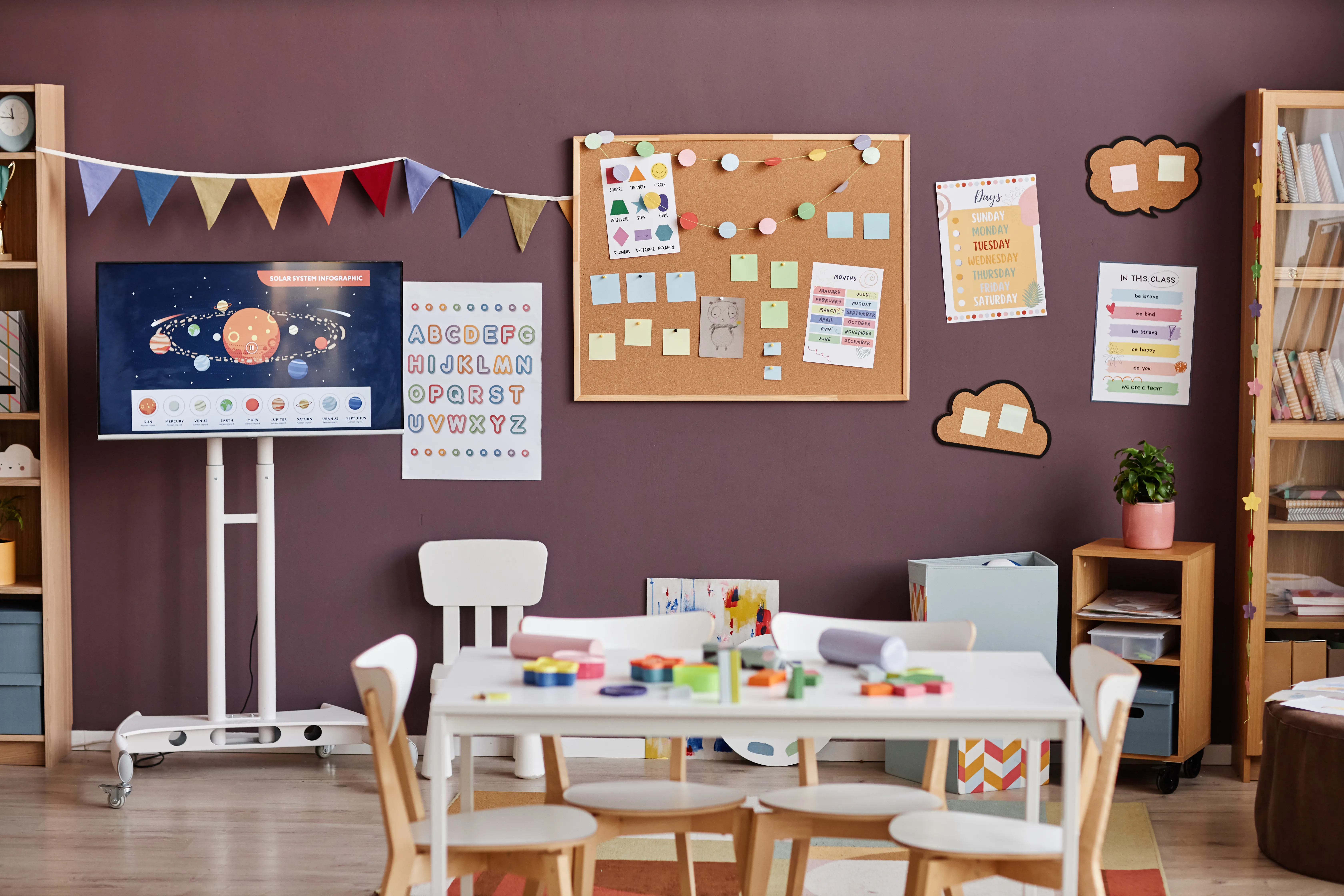 Interior of spacious classroom for nursery schoolkids with table in center