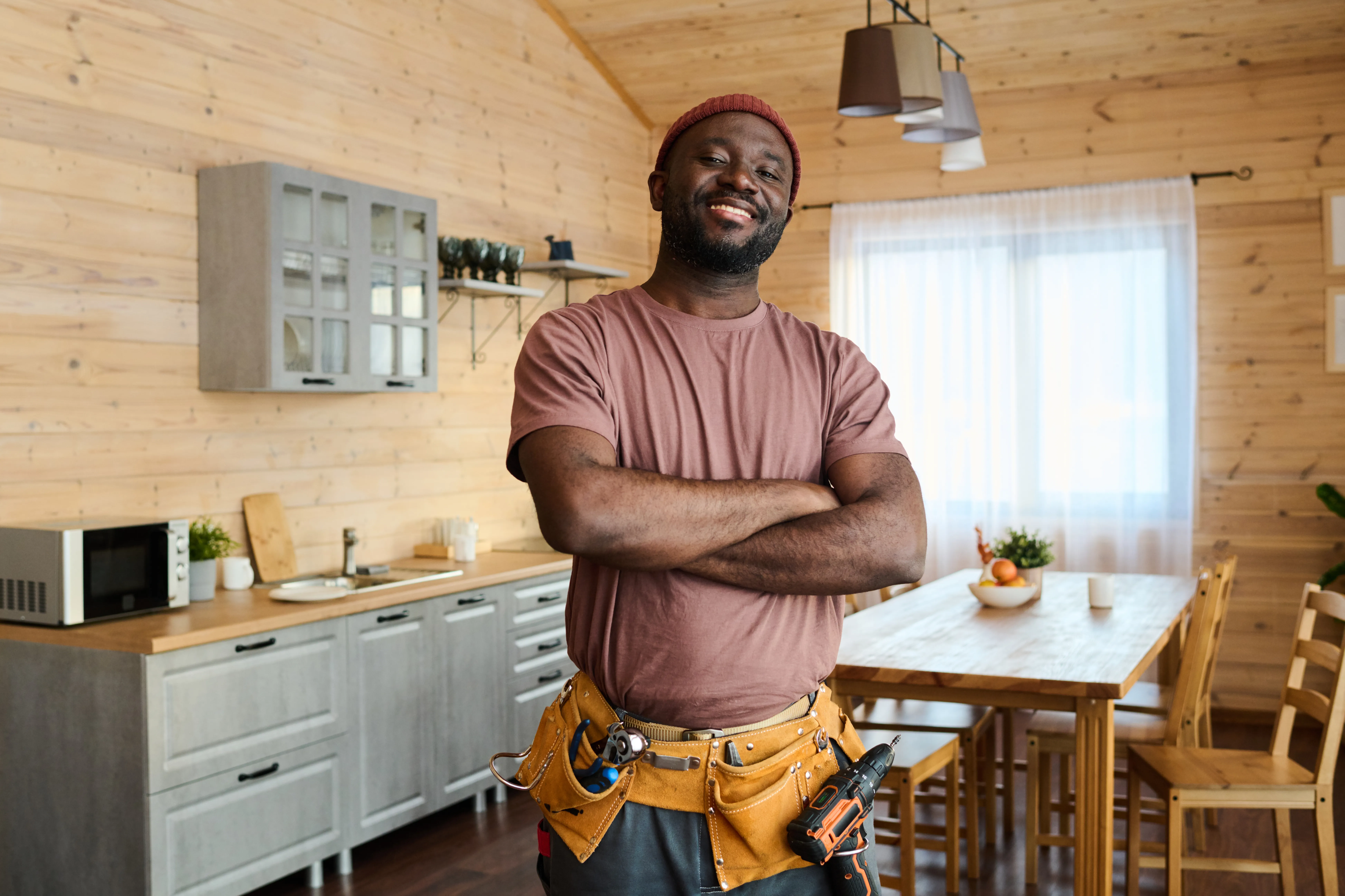 Young cheerful African American repairman or plumber with toolbelt